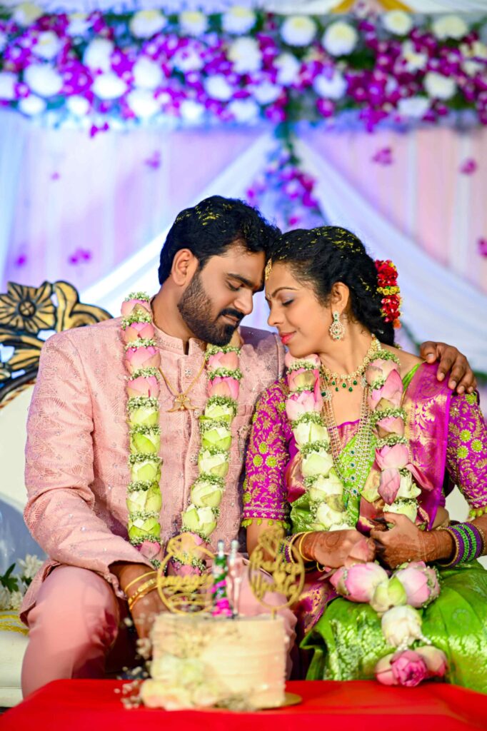 A beautiful Telugu wedding couple sitting and their heads close together, captured in an intimate and lifetime moment by Framesflow photography in Hyderabad