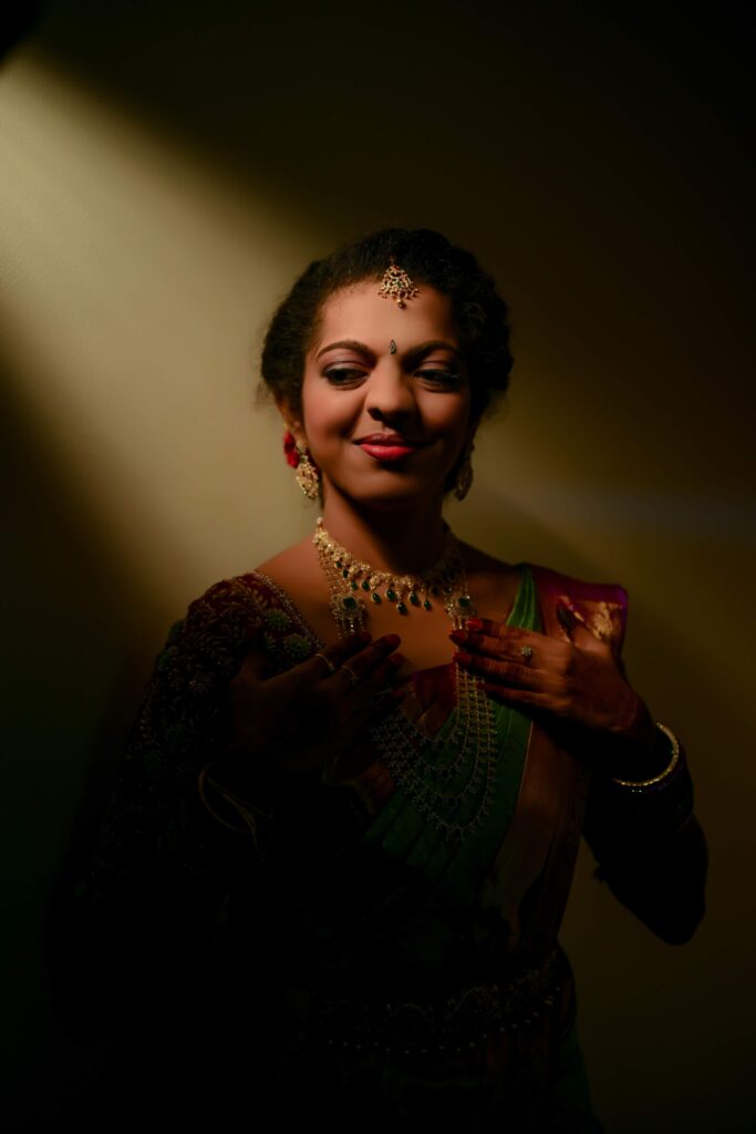 A beautiful Telugu bride standing still, illuminated by light rays, captured by Framesflow Photography in Hyderabad.