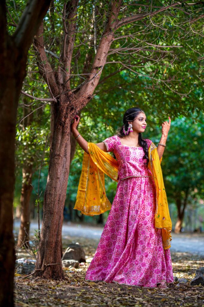 The Telugu bride poses stunning look under a tree during her haldi occasion captures by Framesflow photography in Hyderabad.