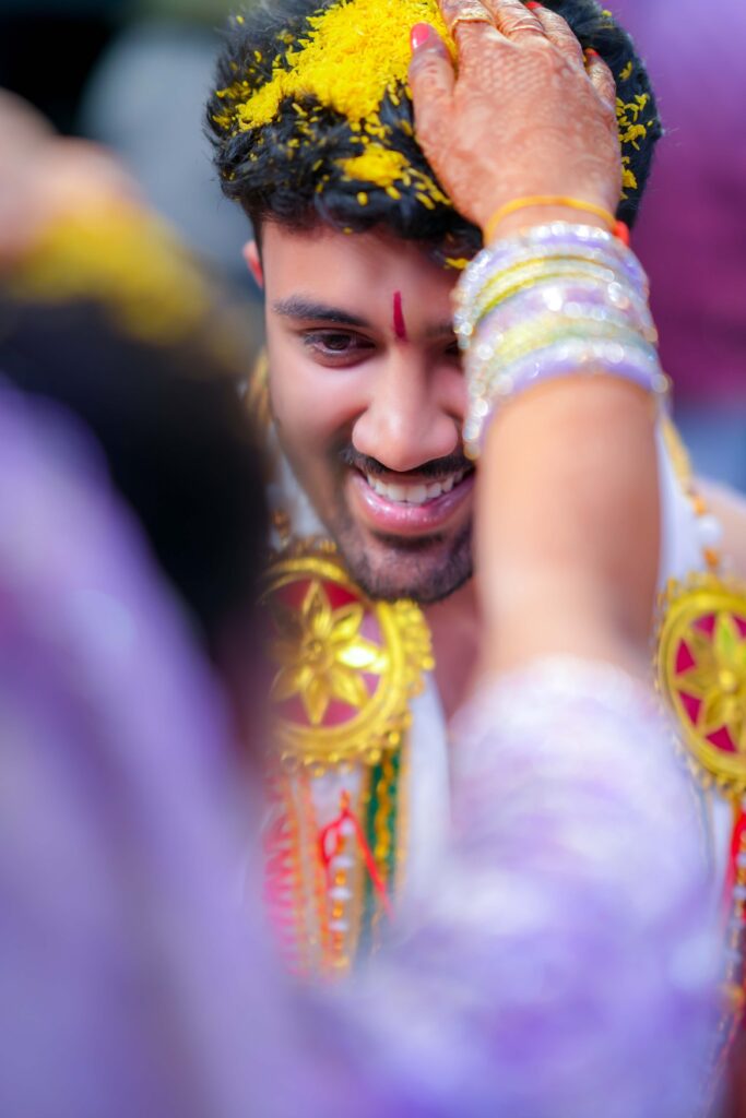 A beautiful Telugu groom admiring behind the groom during their wedding occasion, captures Framesflow photography in Hyderabad.