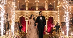 Bride and groom making a cinematic grand entry at a luxury wedding venue in Hyderabad with cold spark effects and professional wedding photography